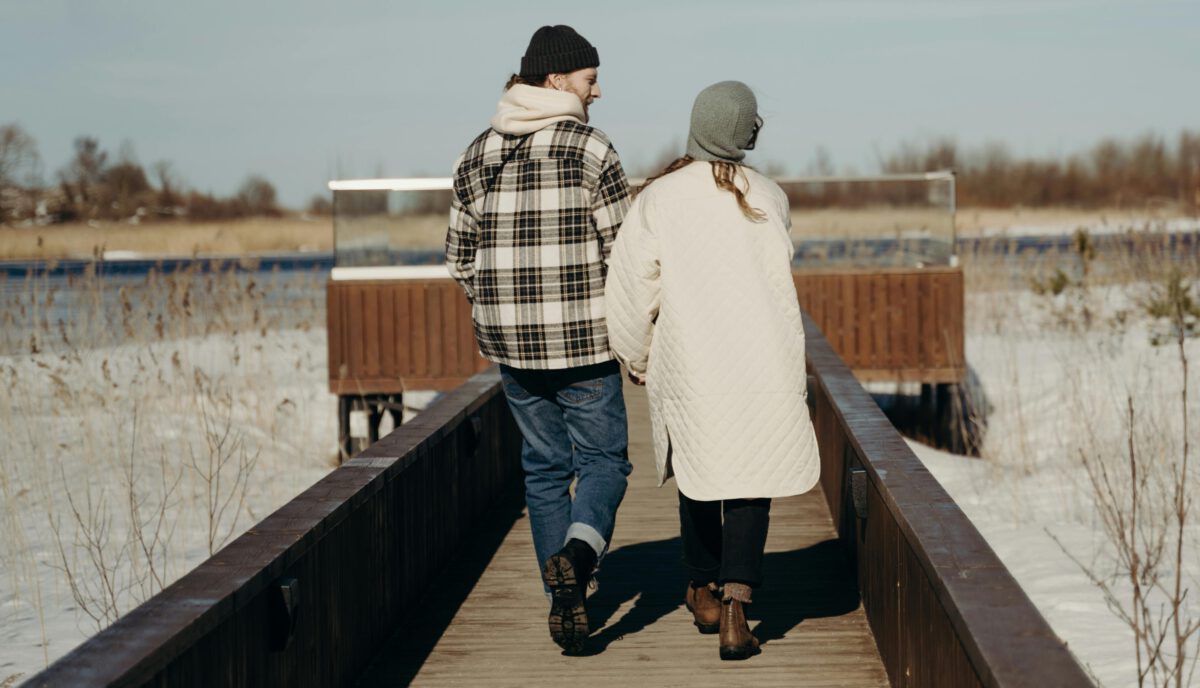 Mann und Frau sind warm angezogen und gehen spazieren