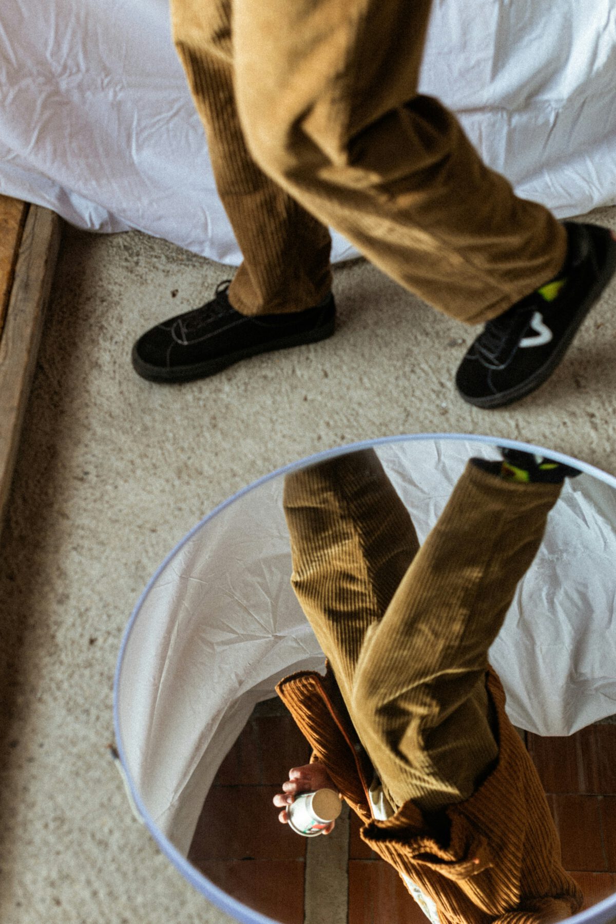 Mann trägt eine Cordhose und spiegelt sich in einem Spiegel