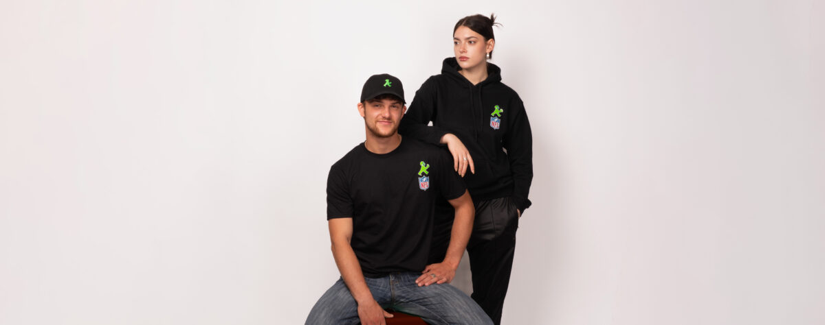 Mann mit NFL x Ampelmann T-Shirt und eine Frau mit einem NFL x Ampelmann Hoodie